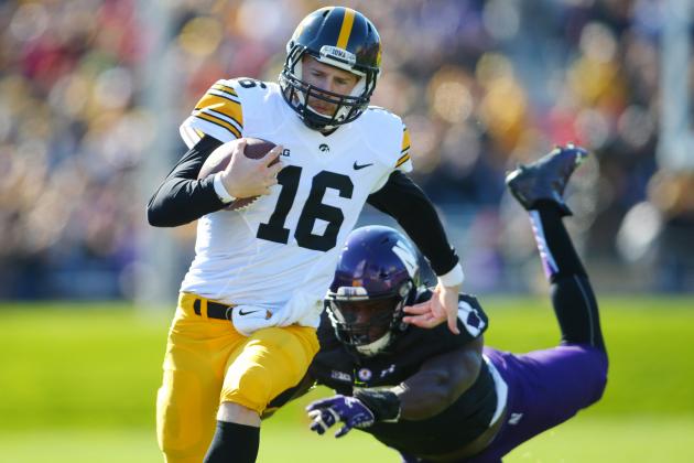 Oct 17, 2015; Evanston, IL, USA; Iowa Hawkeyes quarterback C.J. Beathard (16) avoids the tackle of Northwestern Wildcats safety Traveon Henry (2) during the first half at Ryan Field. Mandatory Credit: Caylor Arnold-USA TODAY Sports