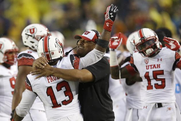 Utah linebacker Gionni Paul (13) is hugged by Assistant Head Coach Kalani Fifita Sitake on the sidelines after he intercepted a pass from Michigan quarterback Devin Gardner during the second half of an NCAA college football game in Ann Arbor, Mich., Saturday, Sept. 20, 2014. (AP Photo/Carlos Osorio)