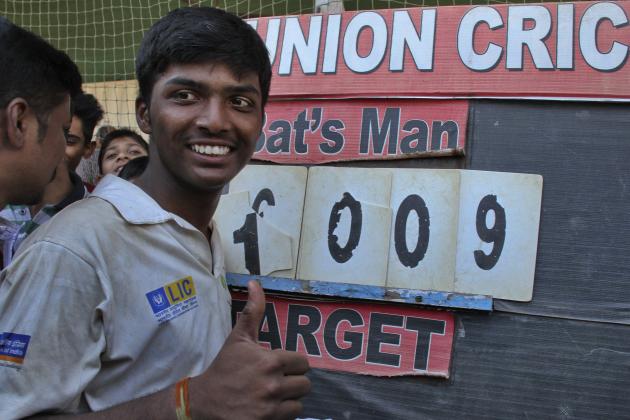 Pranav Dhanawade, a 15-year-old opening batsman, who scored 1009 not out in a tournament recognized by the Mumbai Cricket Association shows a thumbs up gesture as he poses near the score board in Mumbai, India, Tuesday, Jan, 5, 2016. The Mumbai teenager has become the first batsman to score 1000 runs in an officially recognized innings. (AP Photo)