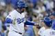 Los Angeles Dodgers' Adrian Gonzalez, left, is greeted by teammate Yasmani Grandal (9), right, after scoring off a single by Andre Ethier in Game 5 of baseball's National League Division Series against the New York Mets Thursday, Oct. 15, 2015, in Los Angeles. (AP Photo/Alex Gallardo)