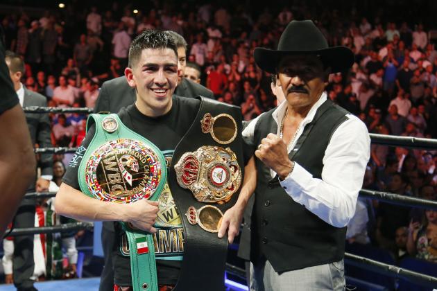 Leo Santa Cruz celebrates with his belts after he was announced the winner against Abner Mares in their WBC diamond featherweight and WBA featherweight championship boxing bout, Saturday, Aug. 29, 2015, in Los Angeles. (AP Photo/Danny Moloshok)