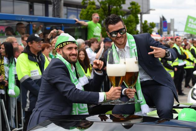 Wolfsburg's midfielder Daniel Caligiuri (L) and Wolfsburg's Portuguese striker Vieirinha pose with large beer glasses on the team's arrival in Wolfsburg, central Germany on May 31, 2015, after the German Cup DFB Pokal final football match between BVB Borussia Dortmund and VfL Wolfsburg on May 30 in Berlin. Wolfsburg won the match 1-3. AFP PHOTO / TOBIAS SCHWARZ (Photo credit should read TOBIAS SCHWARZ/AFP/Getty Images)