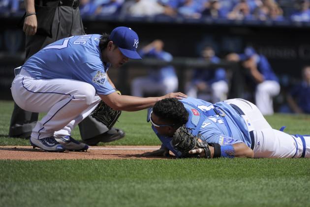KANSAS CITY, MO - MAY 28:  Chien-Ming Wang #67 of the Kansas City Royals looks over Salvador Perez #13  after Perez collided with Cheslor Cuthbert #19 of the Kansas City Royals while catching a foul ball hit by Adam Eaton #1 of the Chicago White Sox in the ninth inning at Kauffman Stadium on May 28, 2016 in Kansas City, Missouri. Perez was injured on the play and left the game. (Photo by Ed Zurga/Getty Images)