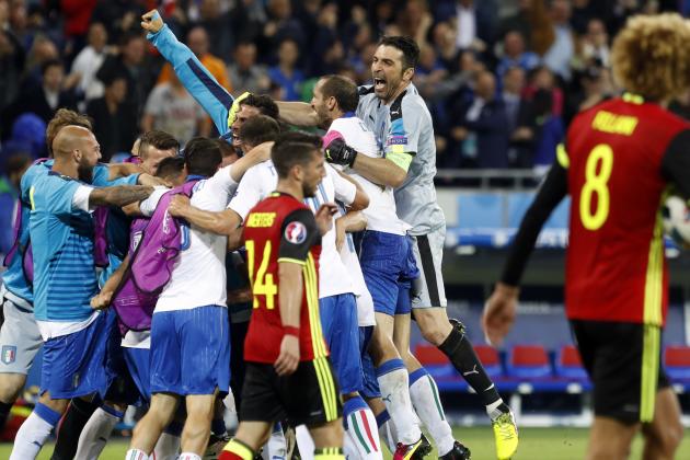 Italy's players celebrate their 2-0 win as Belgium's Marouane Fellaini, right, walks away at the end of the Euro 2016 Group E soccer match between Belgium and Italy at the Grand Stade in Decines-Charpieu, near Lyon, France, Monday, June 13, 2016. (AP Photo/Laurent Cipriani)