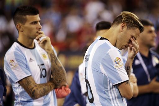 Argentina's Lucas Biglia (6) and his teammate Victor Cuesta wait for trophy presentations after the Copa America Centenario championship soccer match, Sunday, June 26, 2016, in East Rutherford, N.J. Chile defeated Argentina 4-2 in penalty kicks to win the championship. (AP Photo/Julie Jacobson)