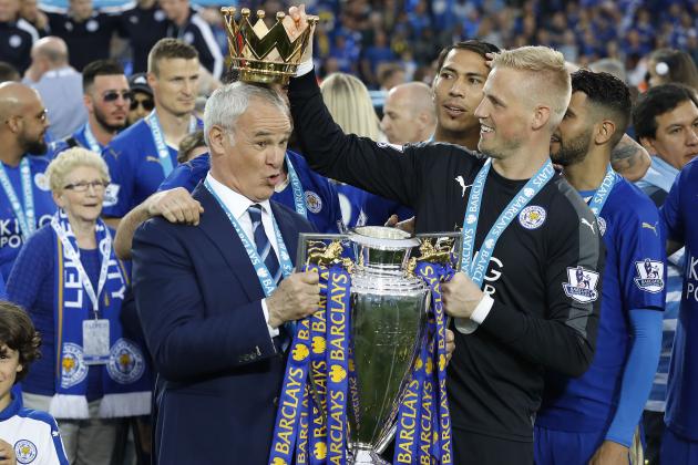 Leicester’s team manager Claudio Ranieri gets a crown by Leicester’s goalkeeper Kasper Schmeichel  as they lift the trophy as Leicester City celebrate becoming the English Premier League soccer champions at King Power stadium in Leicester, England, Saturday, May 7, 2016.(AP Photo/Matt Dunham)