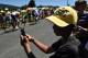A child, wearing a cap with the Tour de France logo, takes pictures with a smartphone as cyclists ride past him during the 160 km fifteenth stage of the 103rd edition of the Tour de France cycling race on July 17, 2016 between Bourg-en-Bresse and Culoz. / AFP / jeff pachoud (Photo credit should read JEFF PACHOUD/AFP/Getty Images)