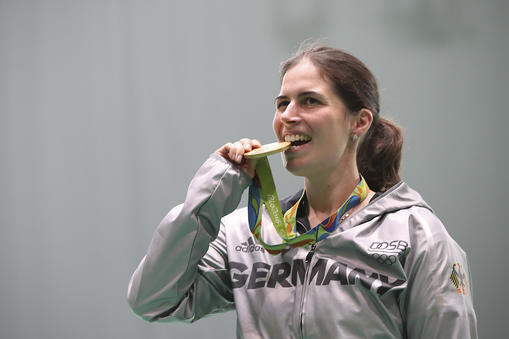 Germany's Barbara Engleder bites her gold medal during the award ceremony for the women's 50 meter rifle 3 positions event at Olympic Shooting Center at the 2016 Summer Olympics in Rio de Janeiro, Brazil, Thursday, Aug. 11, 2016. (AP Photo/Eugene Hoshiko)