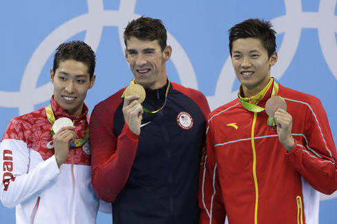 United States' gold medal winner Michael Phelps is flanked by Japan's silver medal winner Kosuke Hagino, left, and China's gold medal winner Wang Shun during the medal ceremony for the men's 200-meter individual medley final during the swimming competitions at the 2016 Summer Olympics, Thursday, Aug. 11, 2016, in Rio de Janeiro, Brazil. (AP Photo/Michael Sohn)