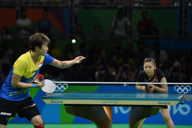 Singapore's Feng Tian Wei (L) eyes the ball as she serves against Japan's Ai Fukuhara in their women's singles quarter-final table tennis match at the Riocentro venue during the Rio 2016 Olympic Games in Rio de Janeiro on August 9, 2016. / AFP / Jim WATSON        (Photo credit should read JIM WATSON/AFP/Getty Images)