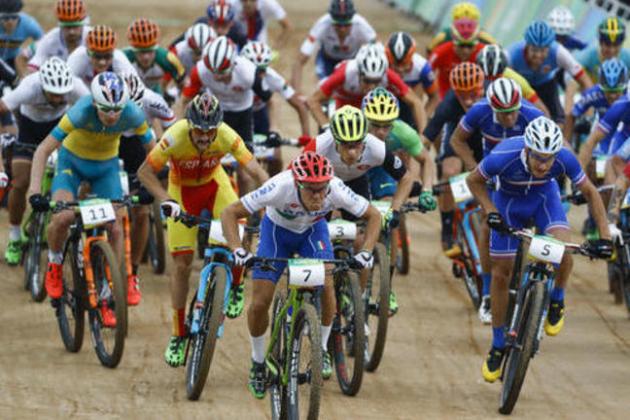 Cyclists, Marco Aurelio Fontana of Italy (7), Victor Koretzky of France (5), Daniel McConnell of Austria (11) and Nino Schurter of Switzerland (3) lead at the start of the men's cross-country cycling mountain bike race at the 2016 Summer Olympics in Rio de Janeiro, Brazil, Saturday, Aug. 20, 2016. (AP Photo/Patrick Semansky)