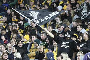 A New Zealand rugby fan waves a flag after the All Blacks scored a try during their Bledisloe Cup Rugby test match against Australia in Sydney, Australia, Saturday, Aug. 20, 2016.(AP Photo/Rob Griffith)
