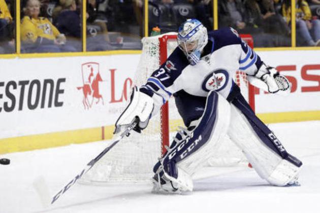 Winnipeg Jets goalie Connor Hellebuyck reaches for the puck during the second period of an NHL hockey game against the Nashville Predators Friday, Nov. 25, 2016, in Nashville, Tenn. (AP Photo/Mark Humphrey)
