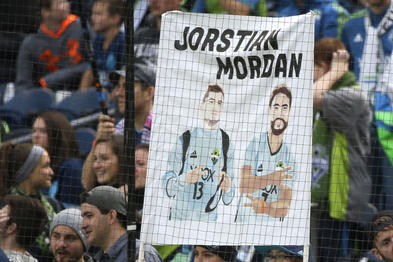 A fan holds a sign promoting how Seattle Sounders' Jordan Morris and Cristian Roldan work closely together, Sunday, Oct. 23, 2016, during an MLS soccer match against Real Salt Lake in Seattle. (AP Photo/Ted S. Warren)