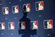 FILE - In this Monday, Feb. 23, 2015 file photo, the shadow of MLB Commissioner Rob Manfred is projected on an MLB logo backdrop in Phoenix. Major league teams steeply increased the money spent on young players in 2015, but the overall percentage of revenue devoted to players has remained relatively stable for a decade. (AP Photo/Ross D. Franklin)