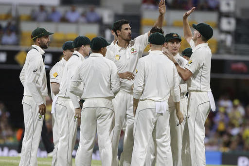 Australia's Mitchell Starc, center, celebrates with his teammates after he got the wicket of Pakistan's Sami Aslam during play on day three of the first cricket test between Australia and Pakistan in Brisbane, Australia, Saturday, Dec. 17, 2016. (AP Photo/Tertius Pickard)