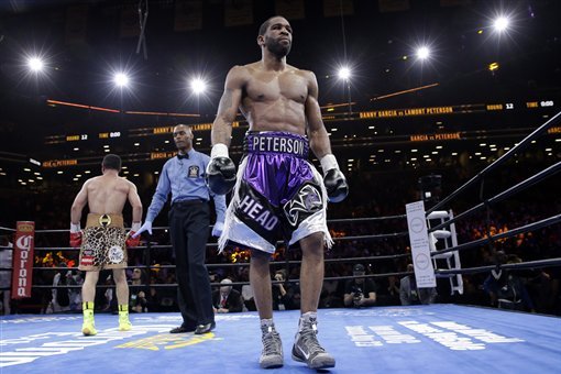 Referee Harvey Dock, center, sends Danny Garcia, left, and Lamont Peterson to their corners in the 12th round during a super lightweight boxing match, Saturday, April 11, 2015, in New York. Garcia won by a majority decision. (AP Photo/Mary Altaffer)