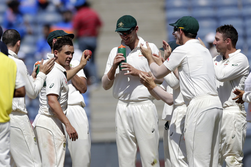 CORRECTS POSITION - Australia's Steve O'Keefe, left, celebrates his tenth wicket in a match during third day of the first cricket test match against India in Pune, India, Saturday, Feb. 25, 2017. (AP Photo/Rajanish Kakade)