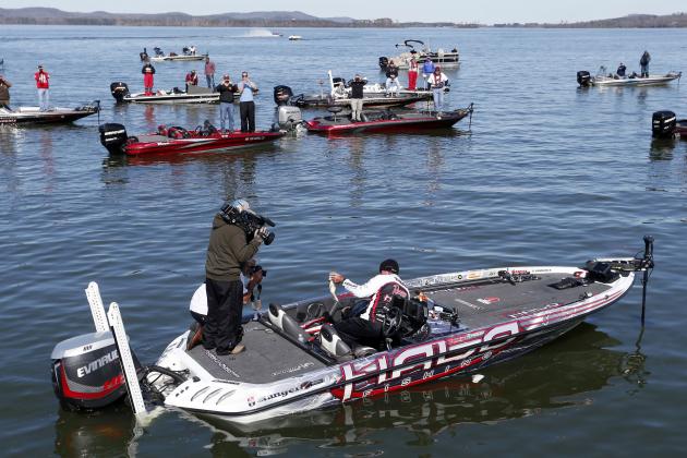 Randall Tharp, Port Saint Joe, Fla., holds up a bass for spectators following him on the second day of the Bassmaster Classic, Saturday, Feb. 22, 2014, in Guntersville, Ala. Tharp was bumped from first to second by 1 ounce by Edwin Evers, Talala, Okla. The field will be cut to the top 25 anglers for the final day of competition. (AP Photo/Hal Yeager)