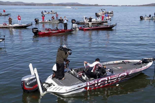 Randall Tharp, Port Saint Joe, Fla., holds up a bass for spectators following him on the second day of the Bassmaster Classic, Saturday, Feb. 22, 2014, in Guntersville, Ala. Tharp was bumped from first to second by 1 ounce by Edwin Evers, Talala, Okla. The field will be cut to the top 25 anglers for the final day of competition. (AP Photo/Hal Yeager)