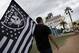 Matt Gutierrez carries a raiders flag by a sign welcoming visitors to Las Vegas, Monday, March 27, 2017, in Las Vegas. NFL team owners approved the move of the Raiders to Las Vegas in a vote at an NFL football annual meeting in Phoenix. (AP Photo/John Locher)