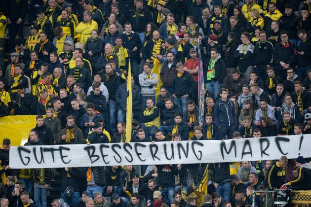 Fans hold a banner reading 'Get well Marc' ahead the UEFA Champions League 1st leg quarter-final football match BVB Borussia Dortmund v Monaco in Dortmund, western Germany on April 12, 2017.
The match had been postponed after three explosions hit German football team Borussia Dortmund's bus injuring two people, including defender Marc Bartra late on April 11, 2017 ahead of a Champions League home game. / AFP PHOTO / Sascha Schuermann        (Photo credit should read SASCHA SCHUERMANN/AFP/Getty Images)