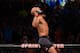 Demetrious Johnson sits atop the UFC Octagon, celebrating his win over Wilson Reis Saturday night.