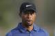 In this Thursday, Feb. 2, 2017 photo, Tiger Woods reacts on hole 10th during the 1st round of the Dubai Desert Classic golf tournament in Dubai, United Arab Emirates. Tiger Woods has withdrawn from the Dubai Desert Classic with an apparent back injury after shooting an opening-round 5-over 77. (AP Photo/Kamran Jebreili)