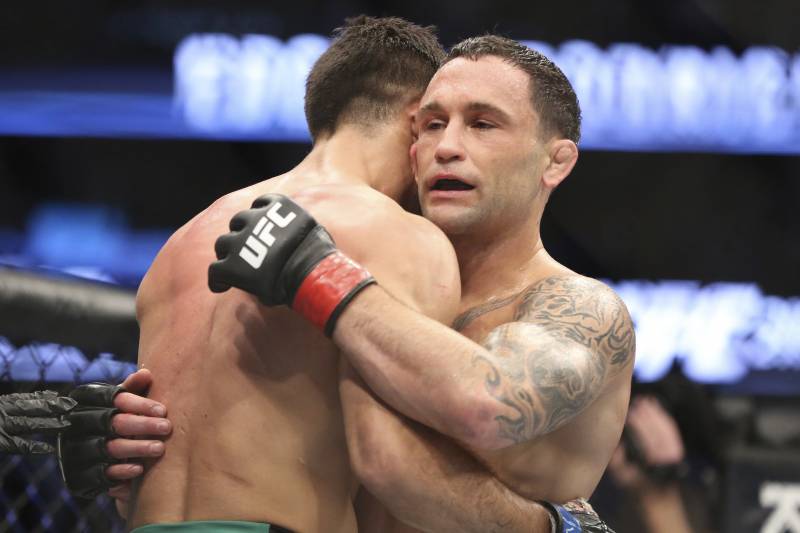 Frankie Edgar hugs Yair Rodriguez after their mixed martial arts bout at UFC 211 on Saturday, May 13, 2017, in Dallas. Edgar won by doctor stoppage after round 2. (AP Photo/Gregory Payan)
