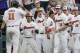 Oregon State designated hitter Trevor Larnach (11) is greeted by teammates including Steven Kwan (4) and George Mendazona (13) after he scored the go-ahead run on a one-run single by Adley Rutschman against Cal State Fullerton in the eighth inning of an NCAA men's College World Series baseball game in Omaha, Neb., Saturday, June 17, 2017. (AP Photo/Nati Harnik)