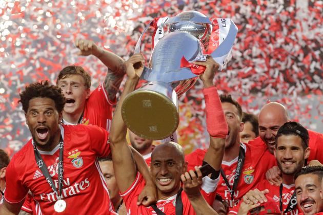 Benfica's Brazilian defender Luisao (C) holds the Portuguese League trophy past teammates as they celebrate winning their 36th title at the end of the Portuguese league football match SL Benfica vs Vitoria Guimaraes SC at the Luz stadium in Lisbon on May 13, 2017.
Lisbon giants Benfica clinched a fourth straight Portuguese league title on May 13, 2017 with a 5-0 victory over Vitoria Guimaraes.
The champions have an unassailable 81 points from 33 games and cannot be caught by Porto, who are eight points behind with just two games to play. / AFP PHOTO / JOSE MANUEL RIBEIRO (Photo credit should read JOSE MANUEL RIBEIRO/AFP/Getty Images)