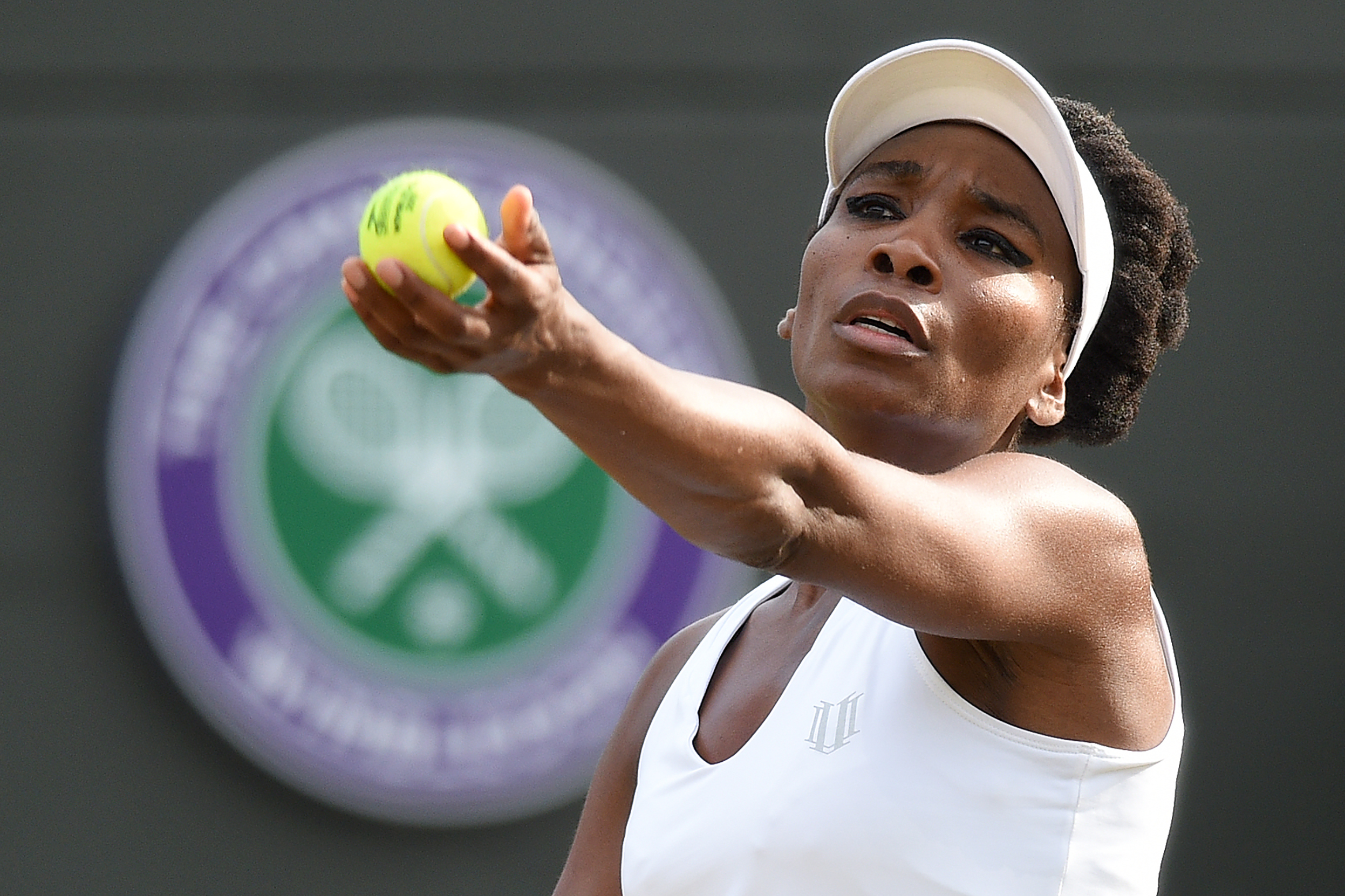 US player Venus Williams serves to Japan's Naomi Osaka during their women's singles third round match on the fifth day of the 2017 Wimbledon Championships at The All England Lawn Tennis Club in Wimbledon, southwest London, on July 7, 2017. / AFP PHOTO / Oli SCARFF / RESTRICTED TO EDITORIAL USE (Photo credit should read OLI SCARFF/AFP/Getty Images)