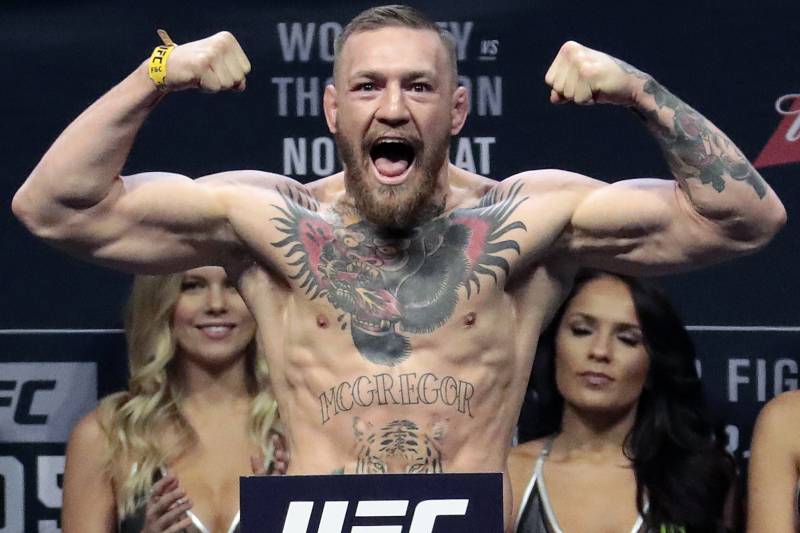 FILE - In this Nov. 11, 2016, file photo, Conor McGregor stands on a scale during the weigh-in event for his fight against Eddie Alvarez in UFC 205 mixed martial arts at Madison Square Garden in New York. Boxer Floyd Mayweather Jr. said Wednesday, June 14, 2017, he will come out of retirement to face UFC star Conor McGregor in a boxing match on Aug. 26. Mayweather, who retired in September 2015 after winning all 49 of his pro fights, will face a mixed martial arts fighter who has never been in a scheduled 12-round fight at the MGM Grand arena. The fight will take place in a boxing ring and be governed by boxing rules. (AP Photo/Julio Cortez, File)
