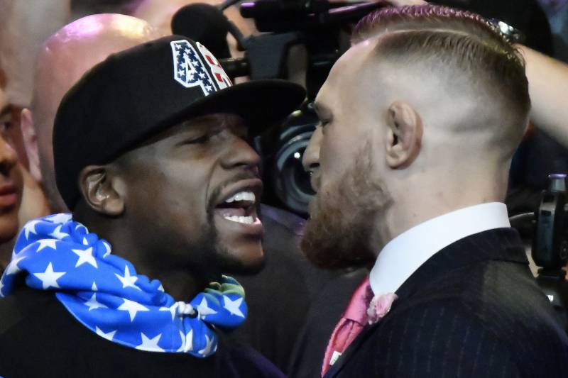 Floyd Mayweather Jr. (L) faces off for the first time with UFC fighter Conor McGregor during a press call at the Staples Center in Los Angeles, California on July 11, 2017. The two will fight August 26th in Las Vegas, Nevada. / AFP PHOTO / Gene Blevins (Photo credit should read GENE BLEVINS/AFP/Getty Images)