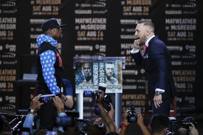 Conor McGregor, right, taunts Floyd Mayweather Jr. while pausing for photos during a news conference at Staples Center Tuesday, July 11, 2017, in Los Angeles. The two will fight in a boxing match in Las Vegas on Aug. 26. (AP Photo/Jae C. Hong)