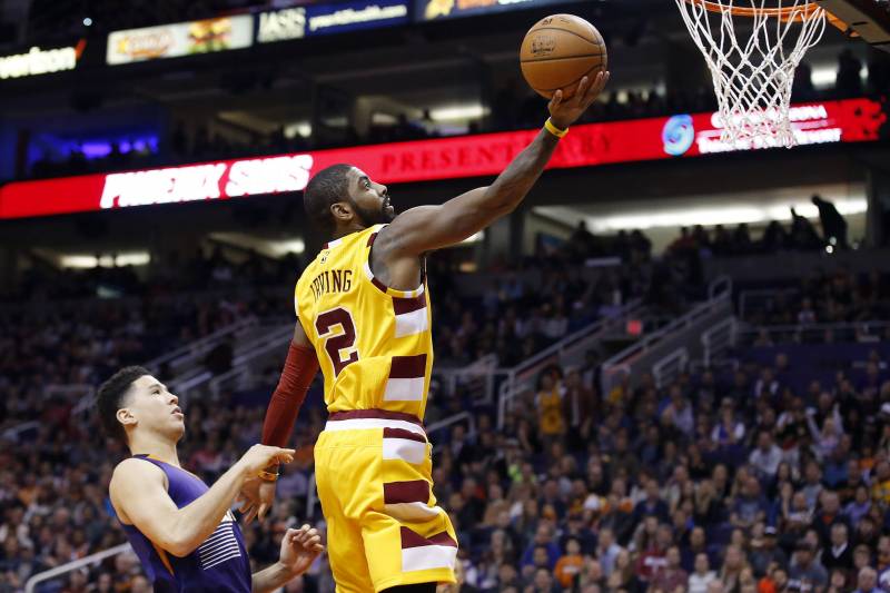 Cleveland Cavaliers' Kyrie Irving (2) drives past Phoenix Suns' Devin Booker, left, for a score during the first half of an NBA basketball game Monday, Dec. 28, 2015, in Phoenix. (AP Photo/Ross D. Franklin)