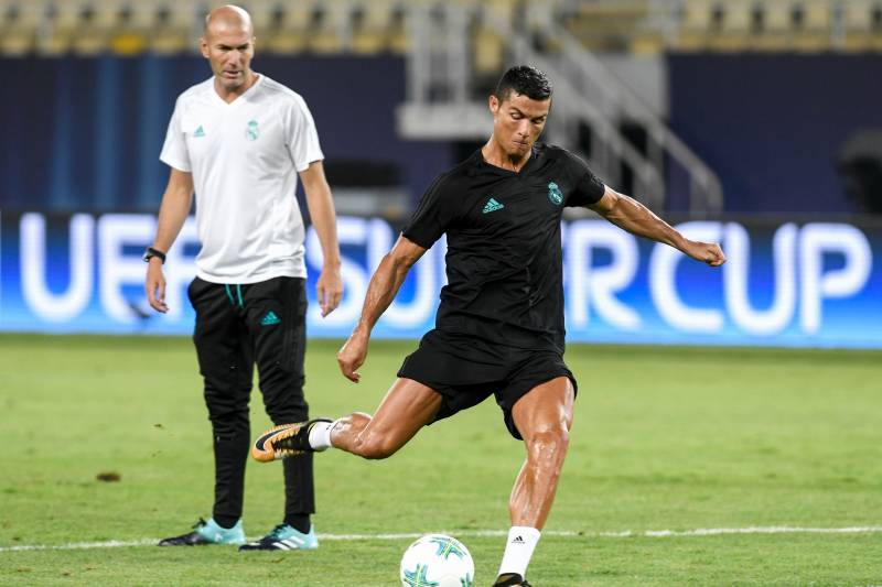 Real Madrid's French head coach Zinedine Zidane (L) looks on as Real Madrid's forward Cristiano Ronaldo shoots the ball during a training session before the UEFA Super Cup 2017 football match between Real Madrid and Manchester United at the National Arena Filip II on August 7, 2017 in Skopje. / AFP PHOTO / NIKOLAY DOYCHINOV        (Photo credit should read NIKOLAY DOYCHINOV/AFP/Getty Images)