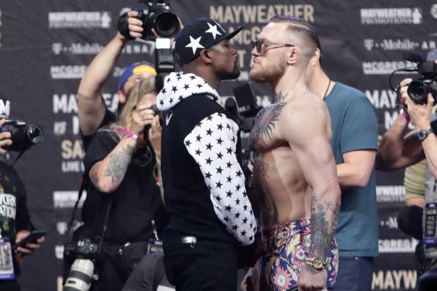 This July 13, 2017 photo shows Floyd Mayweather Jr., left, and Conor McGregor, of Ireland, facing each other for photos during a news conference at Barclays Center in New York. So far fans aren't exactly storming the box office to buy tickets for Mayweather Jr.'s fight next month with McGregor. A check online Saturday, July 29, 2017 revealed hundreds _ even thousands _ of seats still available from Ticketmaster at the T-Mobile arena for the Aug. 26 fight. There are so many open seats that fans with enough room left on their credit cards can buy six tickets together in 162 different spots throughout the arena. (AP Photo/Frank Franklin II)