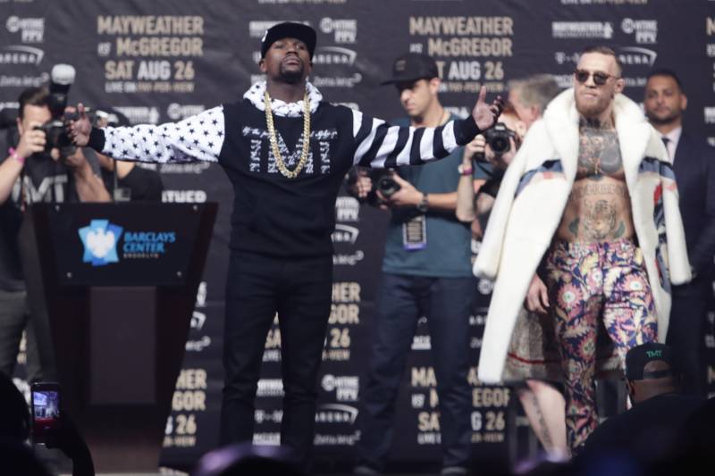 Floyd Mayweather Jr., left, poses as Conor McGregor, right watches during a news conference at Barclays Center Thursday, July 13, 2017, in New York. (AP Photo/Frank Franklin II)