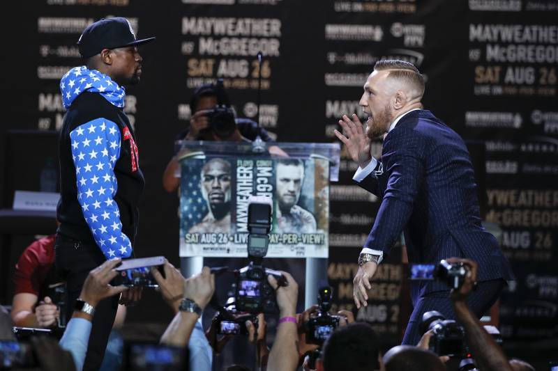 Conor McGregor, right, taunts Floyd Mayweather Jr. while pausing for photos during a news conference at Staples Center on Tuesday, July 11, 2017, in Los Angeles. The two will fight in a boxing match in Las Vegas on Aug. 26. (AP Photo/Jae C. Hong)
