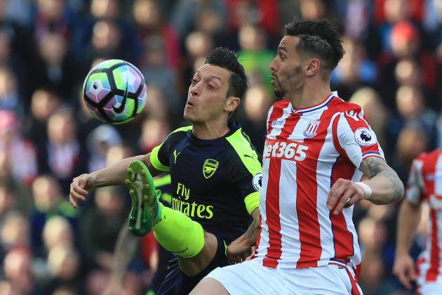 Arsenal's German midfielder Mesut Ozil (L) vies with Stoke City's US defender Geoff Cameron during the English Premier League football match between Stoke City and Arsenal at the Bet365 Stadium in Stoke-on-Trent, central England on May 13, 2017. / AFP PHOTO / Lindsey PARNABY / RESTRICTED TO EDITORIAL USE. No use with unauthorized audio, video, data, fixture lists, club/league logos or 'live' services. Online in-match use limited to 75 images, no video emulation. No use in betting, games or single club/league/player publications.  /         (Photo credit should read LINDSEY PARNABY/AFP/Getty Images)