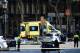 A policemen and a medical staff member stand past police cars and an ambulance in a cordoned off area after a van ploughed into the crowd, injuring several persons on the Rambla in Barcelona on August 17, 2017. / AFP PHOTO / Josep LAGO (Photo credit should read JOSEP LAGO/AFP/Getty Images)