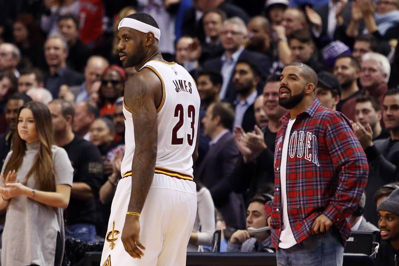 TORONTO, ON - NOVEMBER 25: Singer Drake talks to LeBron James #23 of the Cleveland Cavaliers during an NBA game between the Cleveland Cavaliers and the Toronto Raptors at the Air Canada Centre on November 25, 2015 in Toronto, Ontario, Canada. NOTE TO USER: User expressly acknowledges and agrees that, by downloading and or using this photograph, User is consenting to the terms and conditions of the Getty Images License Agreement. (Photo by Vaughn Ridley/Getty Images)