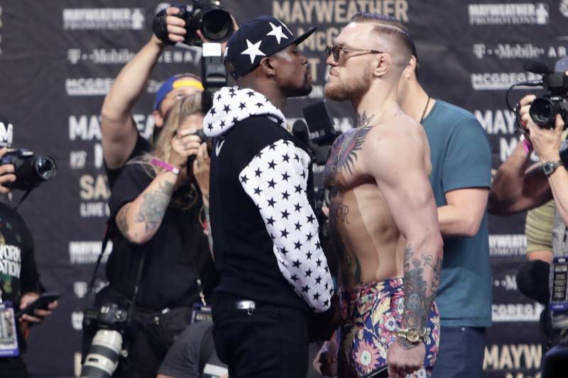 In this July 13, 2017, file photo, Floyd Mayweather Jr., left, and Conor McGregor, of Ireland, face each other for photos during a news conference at Barclays Center in New York. Nevada boxing regulators went out of their way to give a gift to both fighters, approving an exemption to the rule requiring 10-ounce gloves for the 154-pound fight so that both fighters can wear 8-ounce gloves. And just like that, the fight appeared more competitive%26#x2013;at least to some. (AP Photo/Frank Franklin II, File)