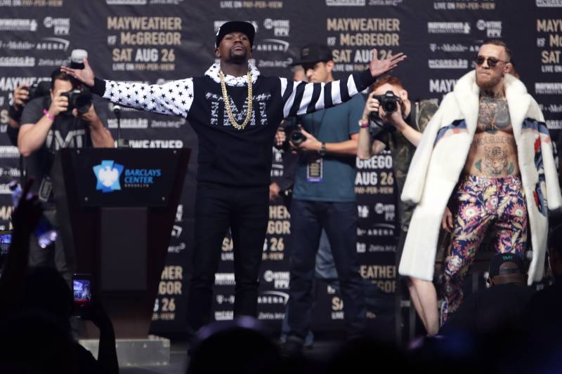 Floyd Mayweather Jr., front left, poses as Conor McGregor, right, watches during a news conference at Barclays Center on Thursday, July 13, 2017, in New York, for their junior middleweight boxing bout next month. (AP Photo/Frank Franklin II)