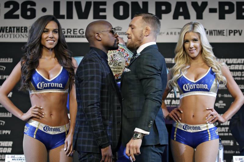 Floyd Mayweather Jr., center left, and Conor McGregor pose for photographers during a news conference Wednesday, Aug. 23, 2017, in Las Vegas. The two are scheduled to fight in a boxing match Saturday in Las Vegas. (AP Photo/John Locher)