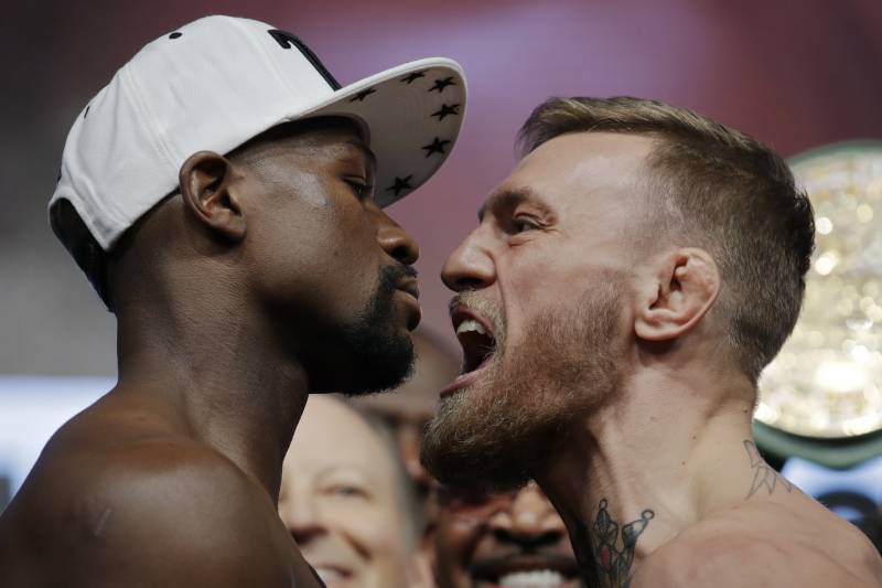 Floyd Mayweather Jr., left, and Conor McGregor face off during a weigh-in Friday, Aug. 25, 2017, in Las Vegas. The two are scheduled to fight in a boxing match Saturday in Las Vegas. (AP Photo/John Locher)