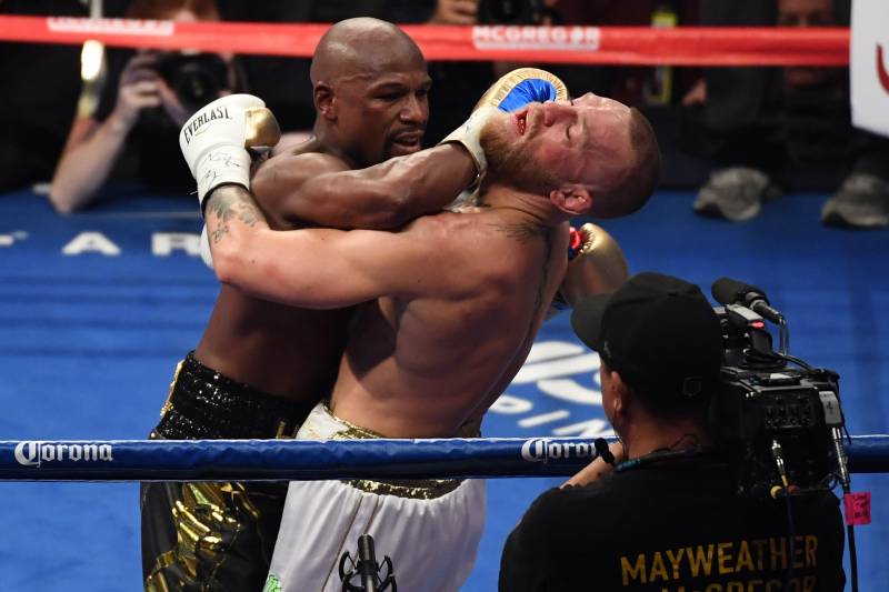 LAS VEGAS, NV - AUGUST 26: (L-R) Floyd Mayweather Jr. throws a punch at Conor McGregor during their super welterweight boxing match on August 26, 2017 at T-Mobile Arena in Las Vegas, Nevada. (Photo by Ethan Miller/Getty Images)