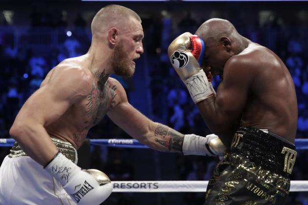 Conor McGregor hits Floyd Mayweather Jr. in a super welterweight boxing match Saturday, Aug. 26, 2017, in Las Vegas. (AP Photo/Isaac Brekken)