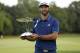 Dustin Johnson holds up his trophy after winning The Northern Trust golf tournament over Jordan Spieth in a playoff on Sunday, Aug. 27, 2017, in Old Westbury, N.Y. (AP Photo/Adam Hunger)